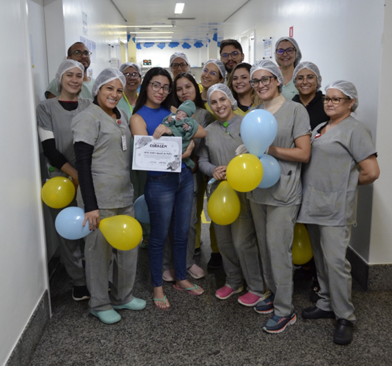 Equipe da UTI Neonatal do HCN com o bebê Uriel e sua mãe, Vanessa Alves, no momento da alta hospitalar. Foto de Cristiano Martins - IMED